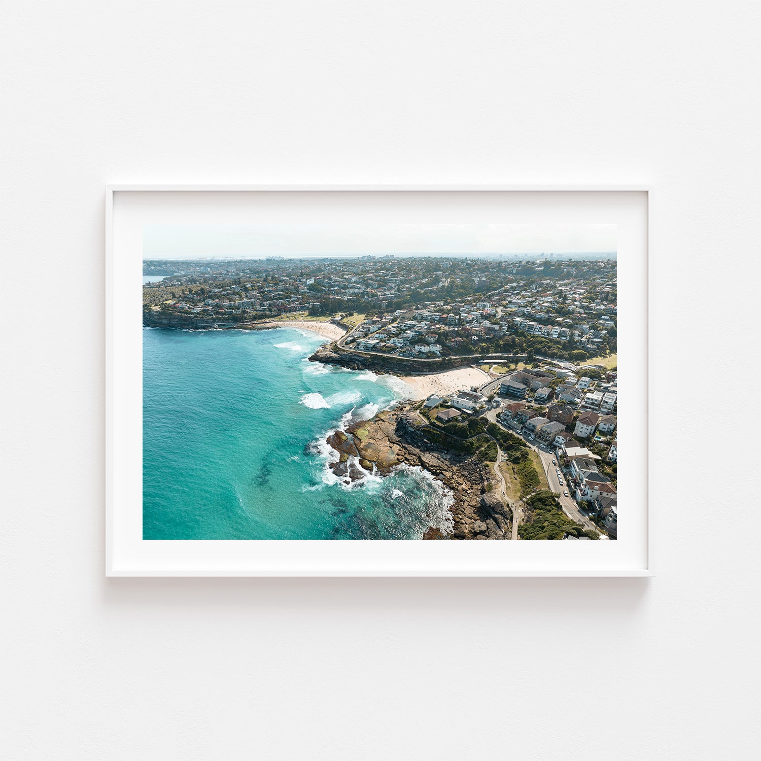 Tamarama neighbours swimming aerial view in white frame - coastal Australian beach wall